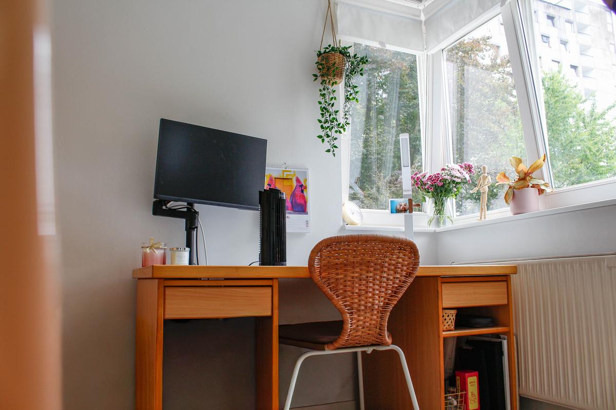 Desk with a monitor and a chair. There is a window on the right.
