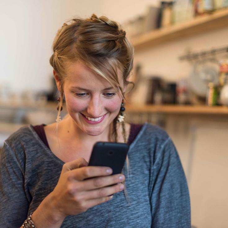 Junge Frau schaut auf ihr Handy