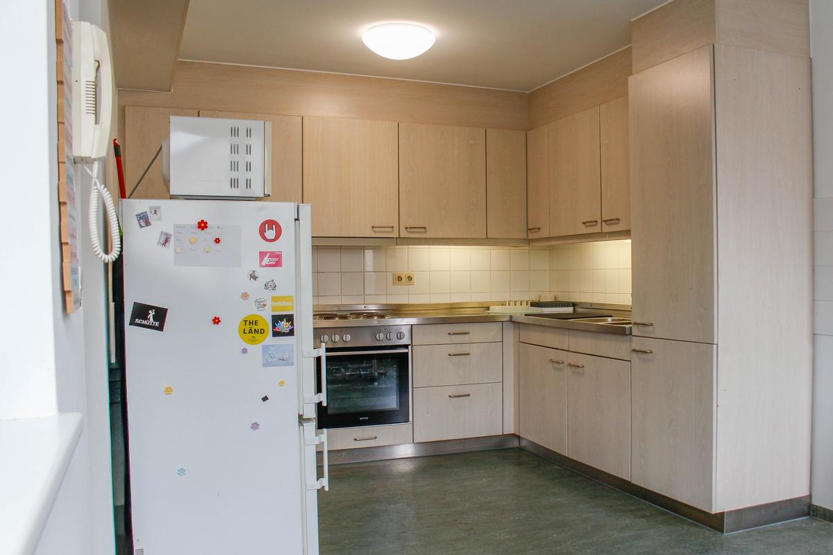 White kitchen with refrigerator, cupboards, oven, and stove