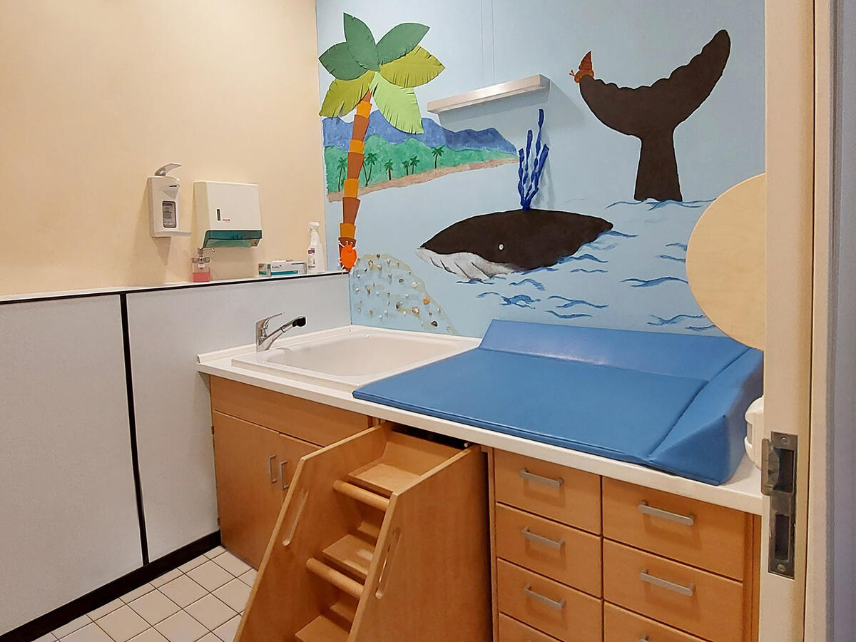 Wickelraum in der Kita Löwenzahn. Auf dem Wandbild ist ein Wal zu sehen.
