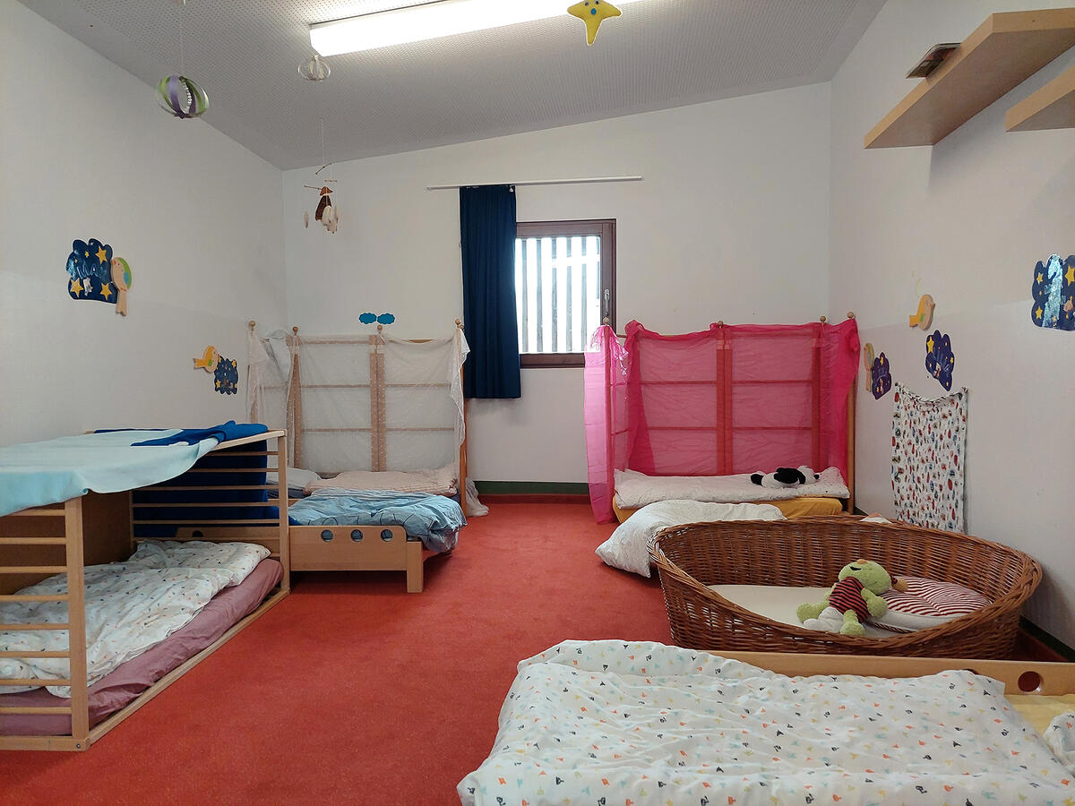 Schlafraum der Kita Pfaffenwald mit Betten und Kuscheltieren