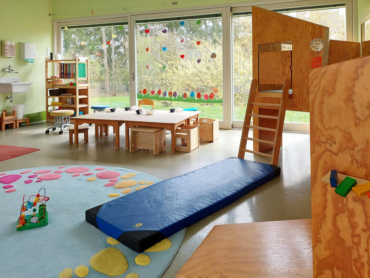 Gruppenraum der Kita Pfaffenwald mit Esstisch und Spielturm