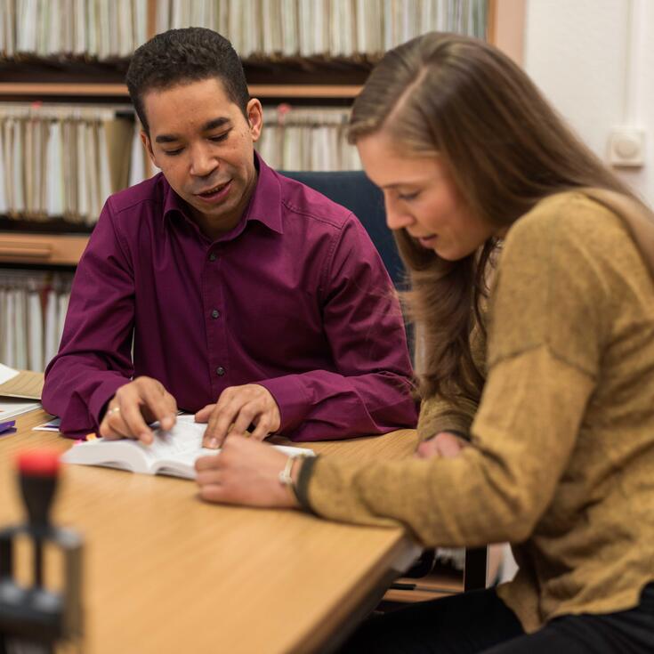 Ein Mitarbeiter des Studierendenwerks berät eine Studentin zum Thema BAföG in einem Büro